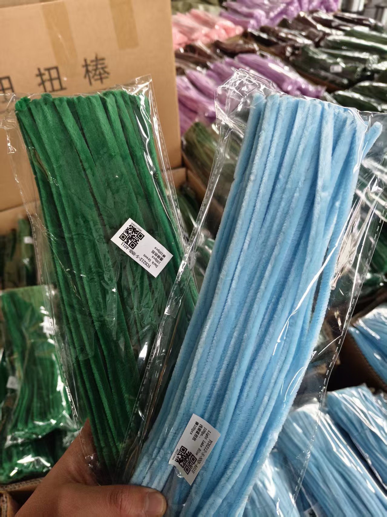 Packaged green and blue chenille stems showing common craft size proportions